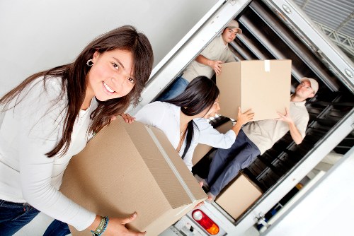 Professional movers handling boxes and furniture in a West Kensington flat