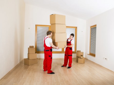 Removal team carrying furniture through a West Kensington flat staircase